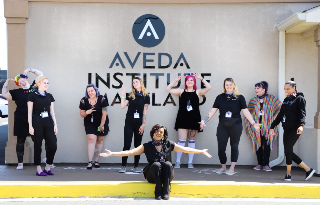Aveda Institute Maryland students and alumni pose for photo in front of school 