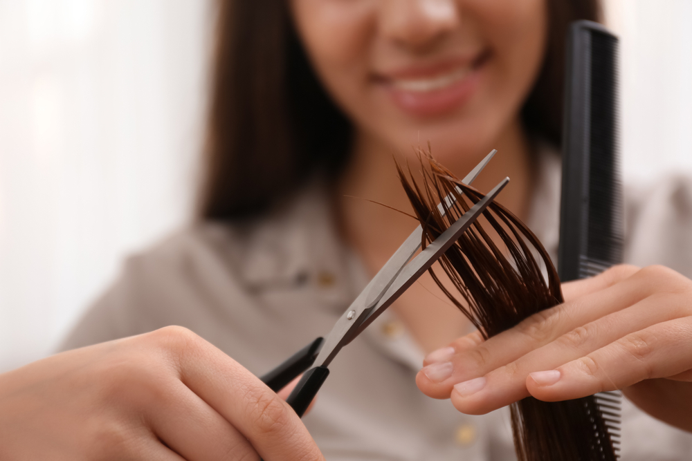 Aveda Institute Maryland cosmetologist cutting a client's hair
